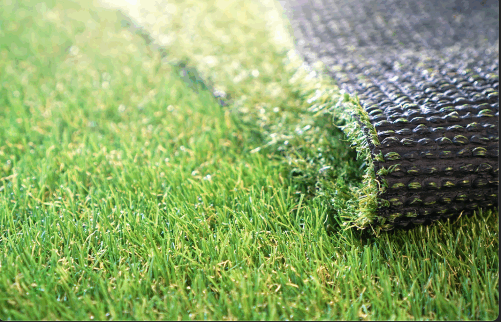 a close up of artificial turf that shows both the grass and the drainage mat underneath